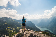 Girl Standing On The Top Of A Cliff Watching A Beautiful Mountain Scenery In The Bavarian Alps