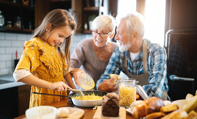 Wall Mural - happy grandchildrens girls having breakfast with her grandparents