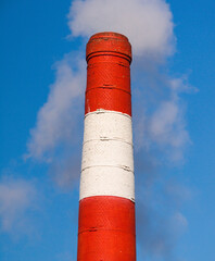 Smokestack releasing smoke into the blue sky