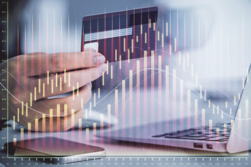 Multi exposure of woman on-line shopping holding a credit card and financial graph drawing. Stock market E-commerce concept.