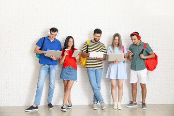  Students with modern devices near light wall