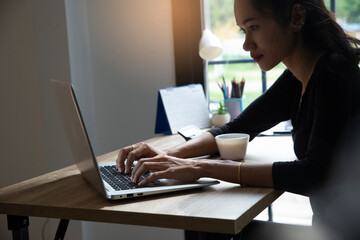 Wall Mural - Remote working at Home office Concept. Businesswoman working online via laptop. Asian young entrepreneurs watching webinars and talking during meeting video conferences calls with team.