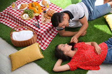 Canvas Print - Happy couple imitating picnic at home, above view