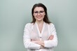 © Valerii Honcharuk - Middle aged smiling happy woman in glasses with crossed arms over green background