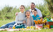 © JackF - Happy smiling young couple with two children having a picnic in sunny day .