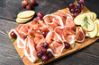 © KEA - Parma ham italian bacon prosciutto crudo or spanish jamon with grapes and crackers on a wooden plate. Food for an aperitif and dinner lunch in the restaurant. food delivery home