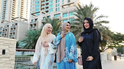 Wall Mural - Three friends making shopping and spending time together in Dubai. Group of women wearing traditional uae abaya clothes outdoor 