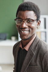 Wall Mural - Portrait of successful African man in eyeglasses and in casual clothing smiling at camera