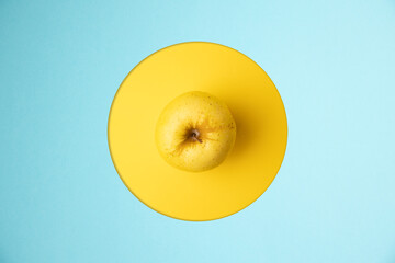 Wall Mural - yellow apple in yellow and blue background