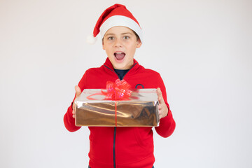 Little boy in red santa hat giving gift box isolated on white background, child giving Christmas present, banner copy space. Isolated on white background.