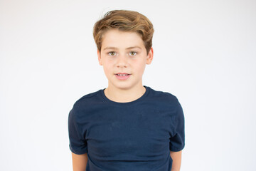 Photo of adorable young happy boy looking at camera over white background.