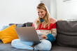 © Drobot Dean - Smiling young woman video calling, using laptop