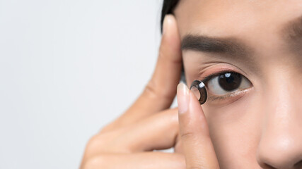 Close-up young Asian woman wearing contact lens.