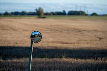 Wall Mural - Small mirror mounted next to a rural road crossing the fields in southern Sweden