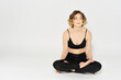 © SHOTPRIME STUDIO - Woman in leggings meditate in a light room with her legs crossed yoga asana
