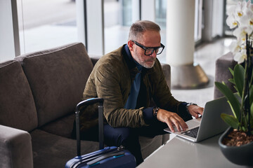 Wall Mural - Serious bearded man using his computer indoors