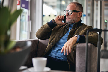 Wall Mural - Grey-haired Caucasian man making a phone call