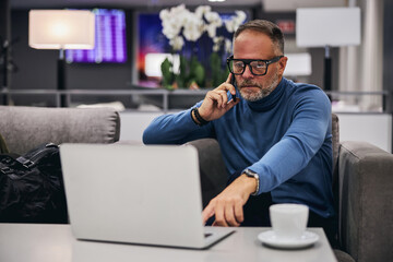 Wall Mural - Concentrated businessman reading news on his computer