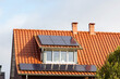 Solar panels on a red roof with dormer for electric power generation