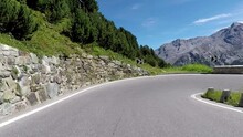 Motorcycle curves driving up the Stelvio Pass by motorbike along cyclists driving up the mountain road. Includes two different video sequences!