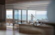 © Trevor Adeline/Caia Image - Woman looking at sunny ocean view on luxury home showcase balcony