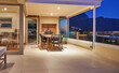 © Trevor Adeline/Caia Image - Dining table on luxury home showcase patio at night