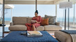 © Trevor Adeline/Caia Image - Woman relaxing with digital tablet on luxury home showcase sofa
