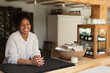© Martin Barraud/Caia Image - Portrait happy friendly female shop owner at counter