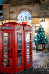 Wall Mural - Red telephone booths in front of Christmas decorations lights in the Covent Garden district, London, United Kingdom