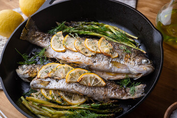 Poster - grilled trout with lemon and herb on iron skillet pan