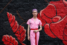 Portrait Stylish Non-binary Young Adult At Painted Mural Wall