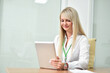 © pridannikov - Young blonde woman looking information in tablet computer in office