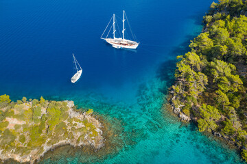 two yachts in emerald bay between two green shores