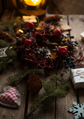 Wall Mural - Christmas wreath with pine cones,acorns and autumn berries, gifts/process of making christmas wreath/handmade decorations for winter holidays