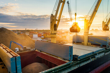 large international transportation vessel in the port, loading grain during sunrise for export in th