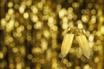 Two glasses of champagne on golden background, with copy space. champagne on golden stylish background with golden bokeh.