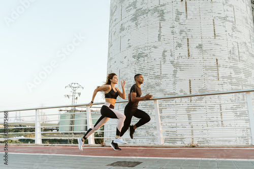 Fotografía Multiethnic athletes running in industrial cityscape