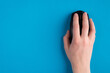 © ActionGP - Top above overhead close up first person view photo of human female hand holding laptop computer wireless black mouse isolated over bright color blue background