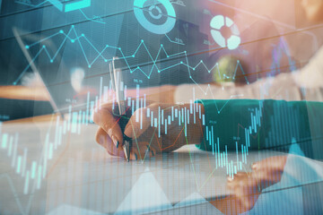 Double exposure of forex chart drawing over people taking notes background. Concept of financial analysis