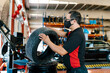 © Ezequiel Gimenez/Westend61 - Mechanic wearing mask examining tire in auto repair shop