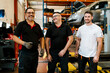 © Ezequiel Gimenez/Westend61 - Smiling male coworkers standing in auto repair shop