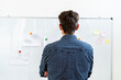 © Giorgio Fochesato/Westend61 - Architect standing while looking at paper pin on whiteboard at office