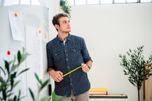 Thoughtful Man Leaning On Whiteboard While Standing At Office