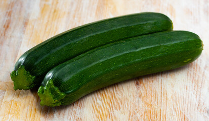 Wall Mural - Close-up of fresh green zucchini on wooden desk in kitchen..