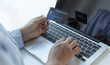 © Puwasit Inyavileart - Women use laptop register via credit cards to make online purchases.