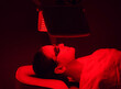 © Space_Cat - Young woman having red LED light facial therapy treatment in beauty salon. Beauty and wellness