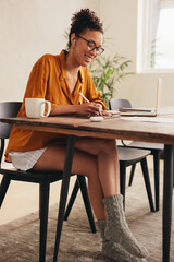 Wall Mural - Woman working on a digital tablet at home