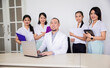 © Space_Cat - Portrait of confident asian medical team looking at a camera. Female nurses or students standing around male doctor or teacher in clinic office or hospital room