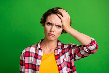 Wall Mural - Close up portrait of irritated lady arm on head pain head ache wear checkered isolated on green color background