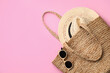 © New Africa - Elegant woman's straw bag with hat and sunglasses on pink background, top view. Space for text